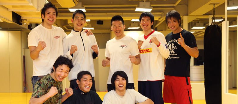 笑顔で集合したボスジムのキックボクシング選手とコーチ